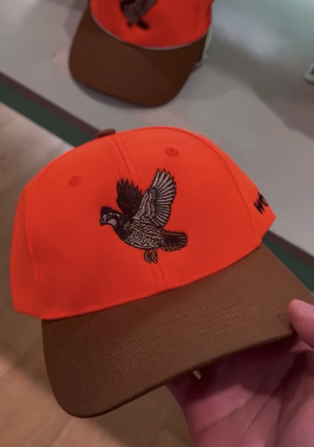 Orange and brown corporate hat with embroidered pheasant artwork