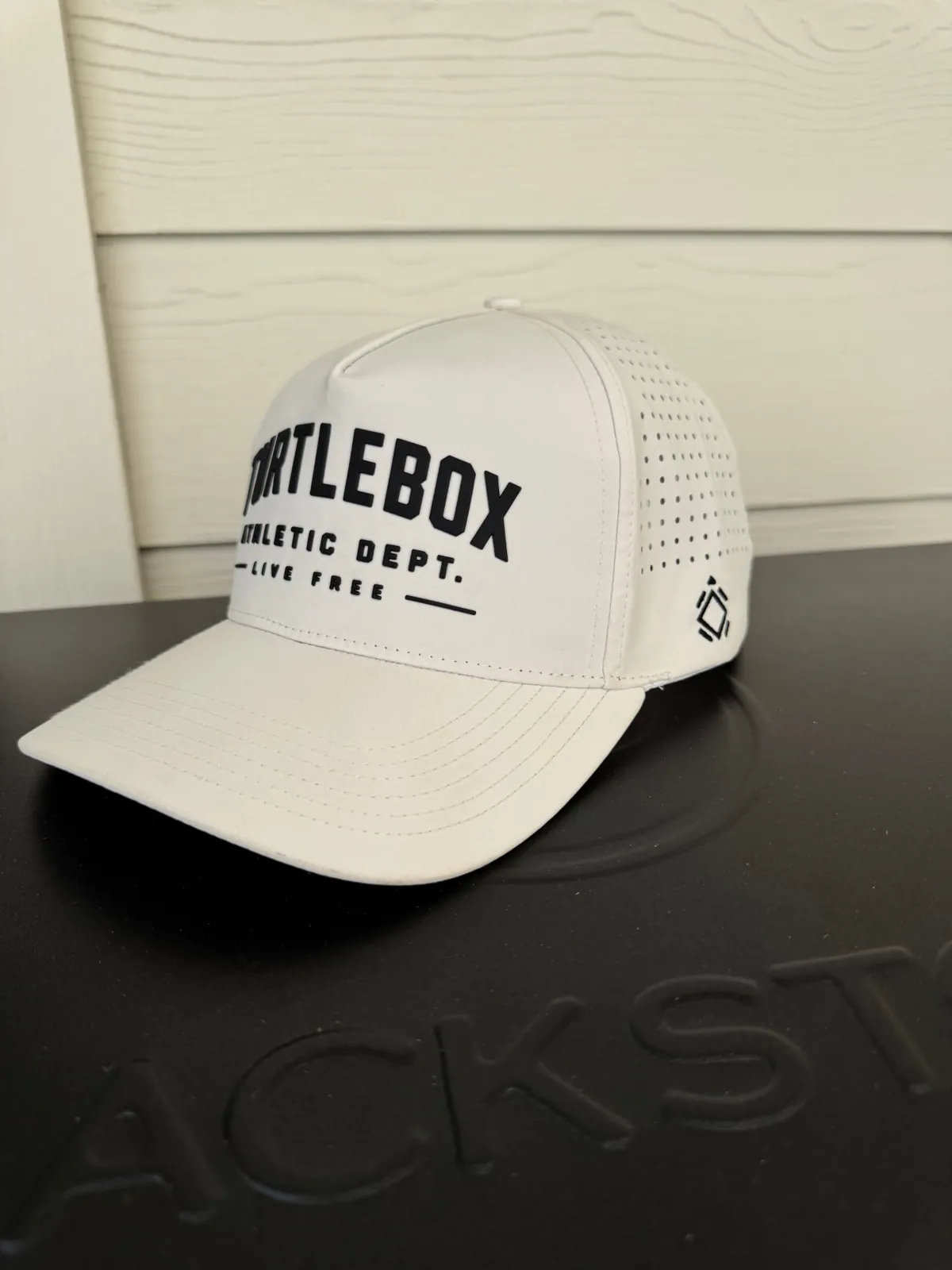 White perforated performance hat with black front and side business embroidery
